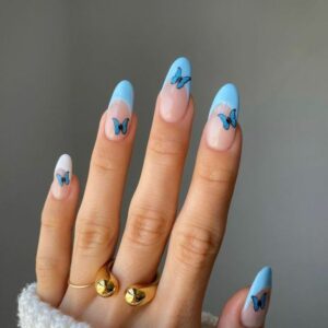 manicura francesa azul con mariposas