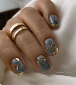 uñas grises con flores en oro